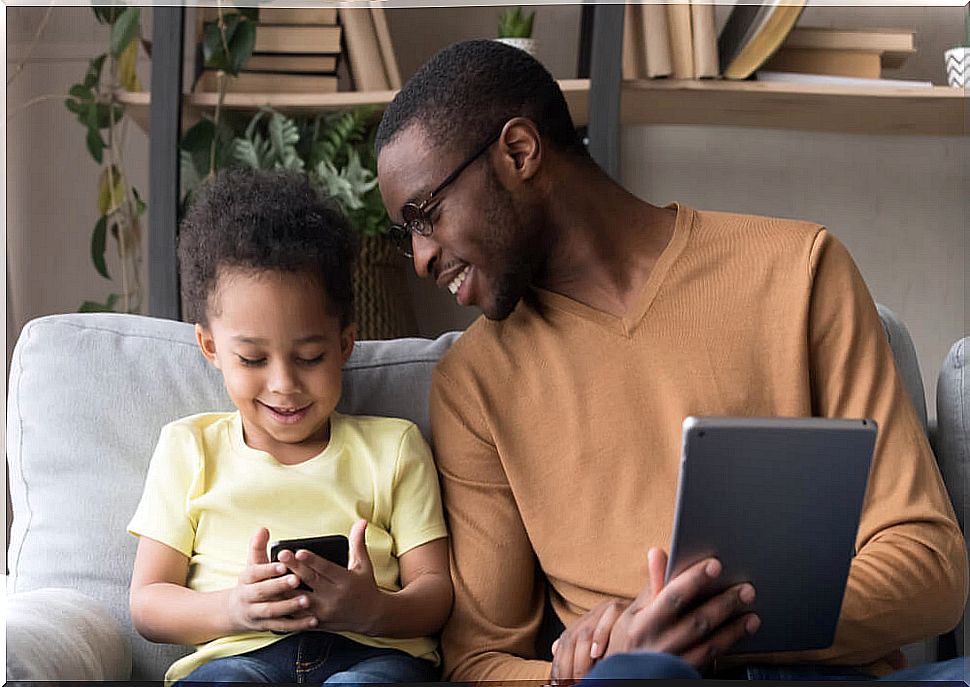 Father with his son playing with some of the applications to cope with the isolation.