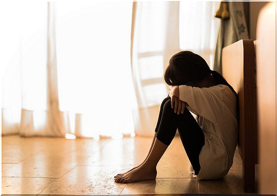 Girl sitting on the floor sad.