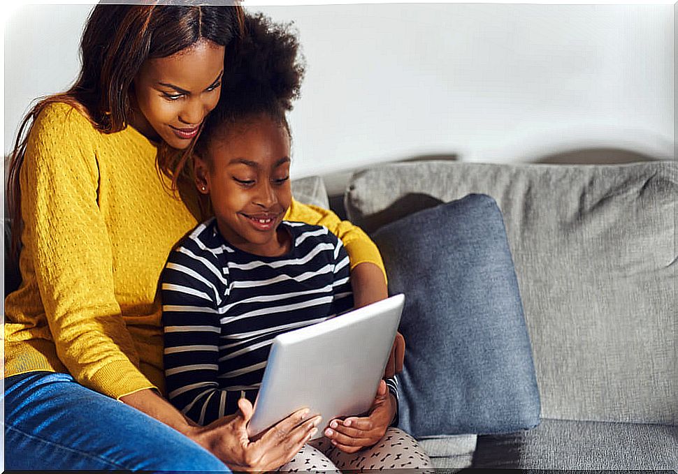 Mother with her daughter playing with educational apss to learn spelling.