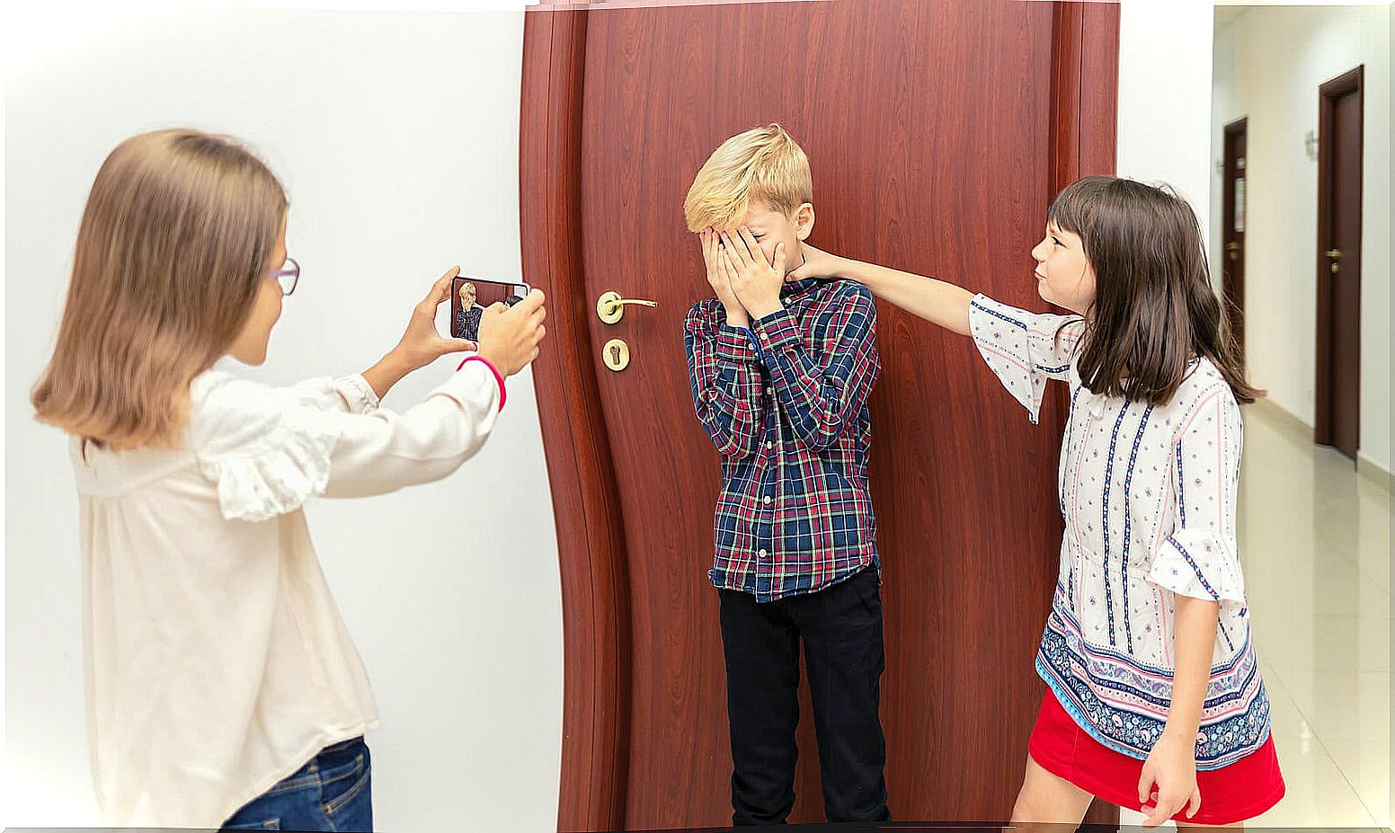 Girls taking photos of a partner who is bullied.