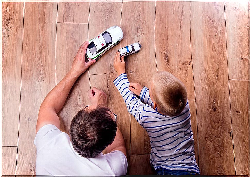 Father and son playing cars together.