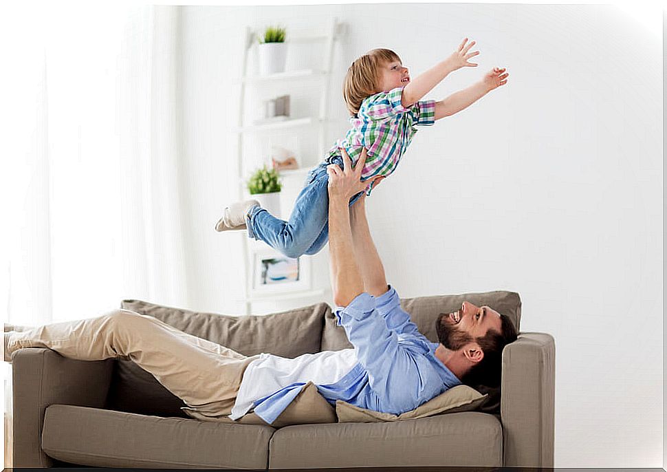 Involved father playing with his son on the couch.