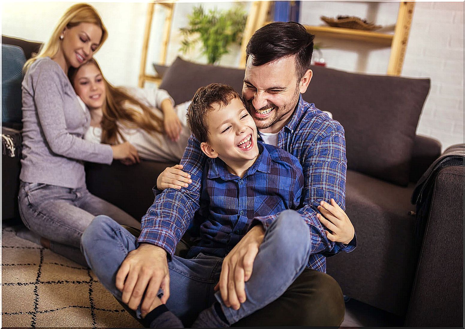 Parents playing with their children in the living room at home.