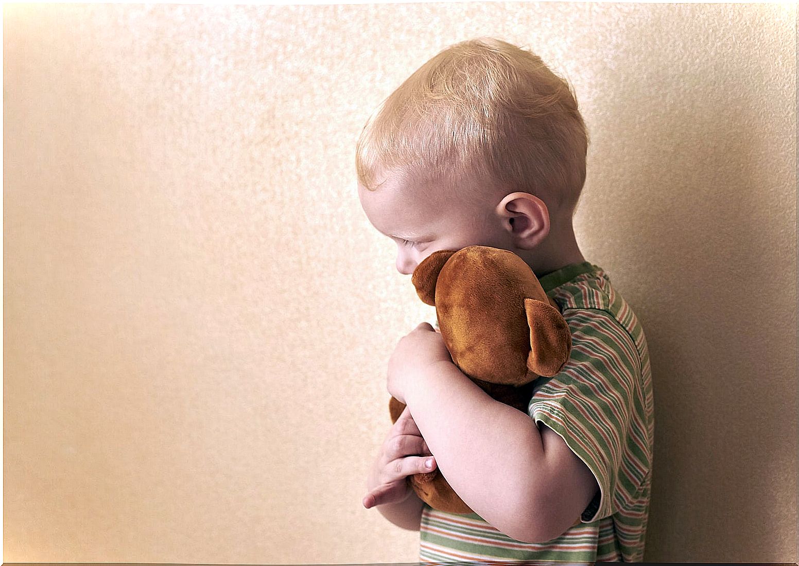 Boy hugging a stuffed animal because he is afraid of death.