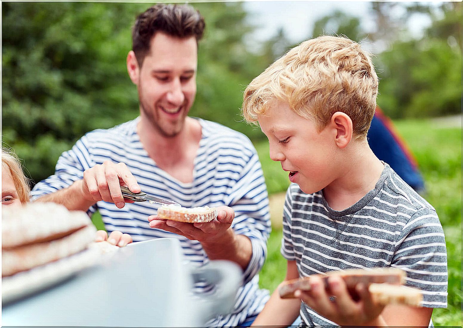 Father with his son making sandwiches for the family outing.