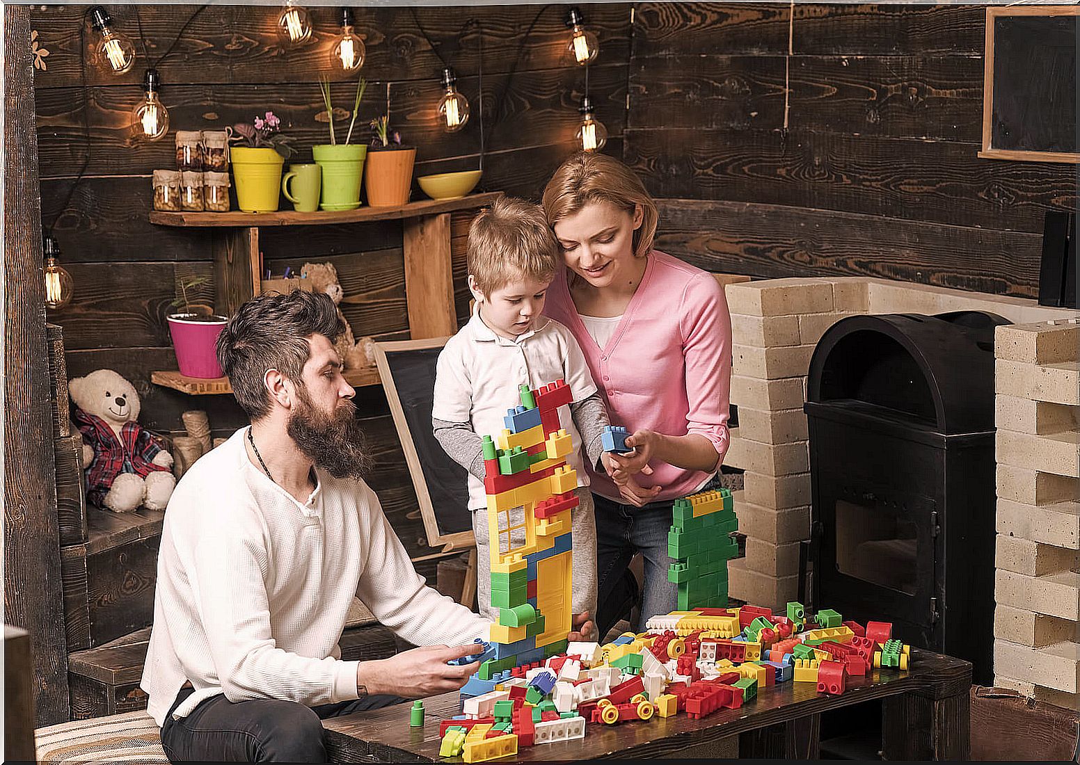 Parents playing with their child conducting LEGO therapy for children with autism.