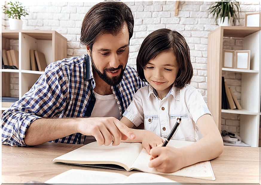 Father helping his son with homework in a good space at home.