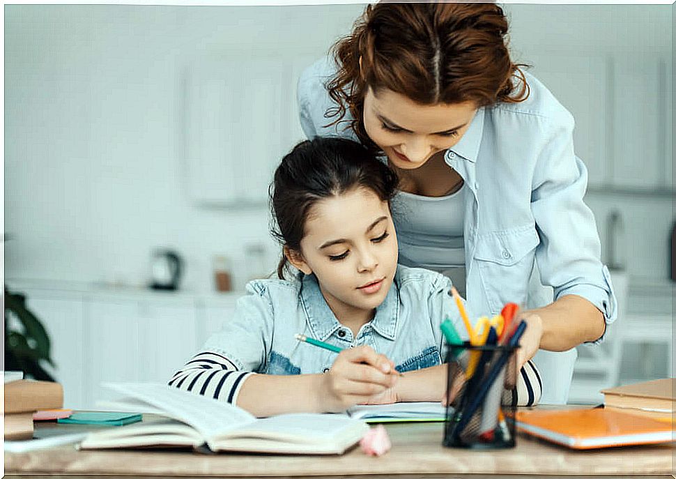 Girl doing homework at home with the help of her mother, who follows the keys to redirect the child at school.