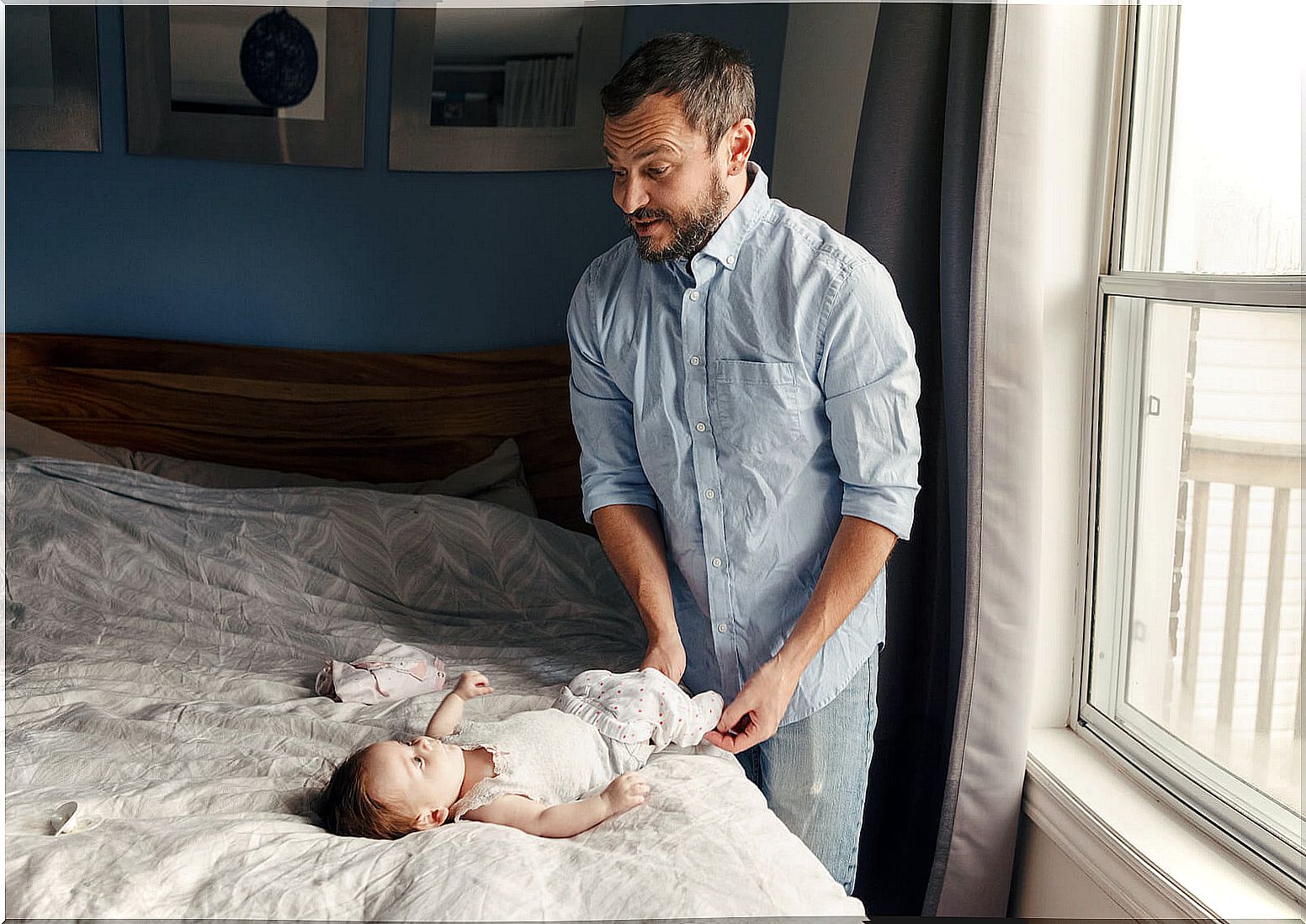 Father changing his baby's diaper.