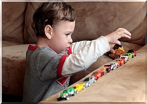 Boy with autism playing with cars on the couch.