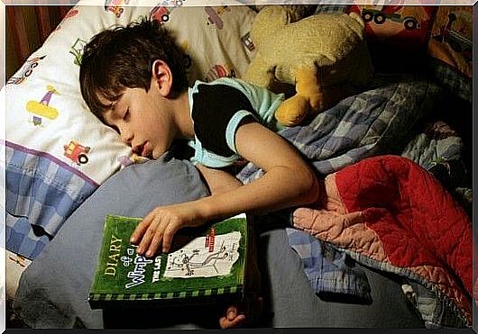 boy with a book in bed