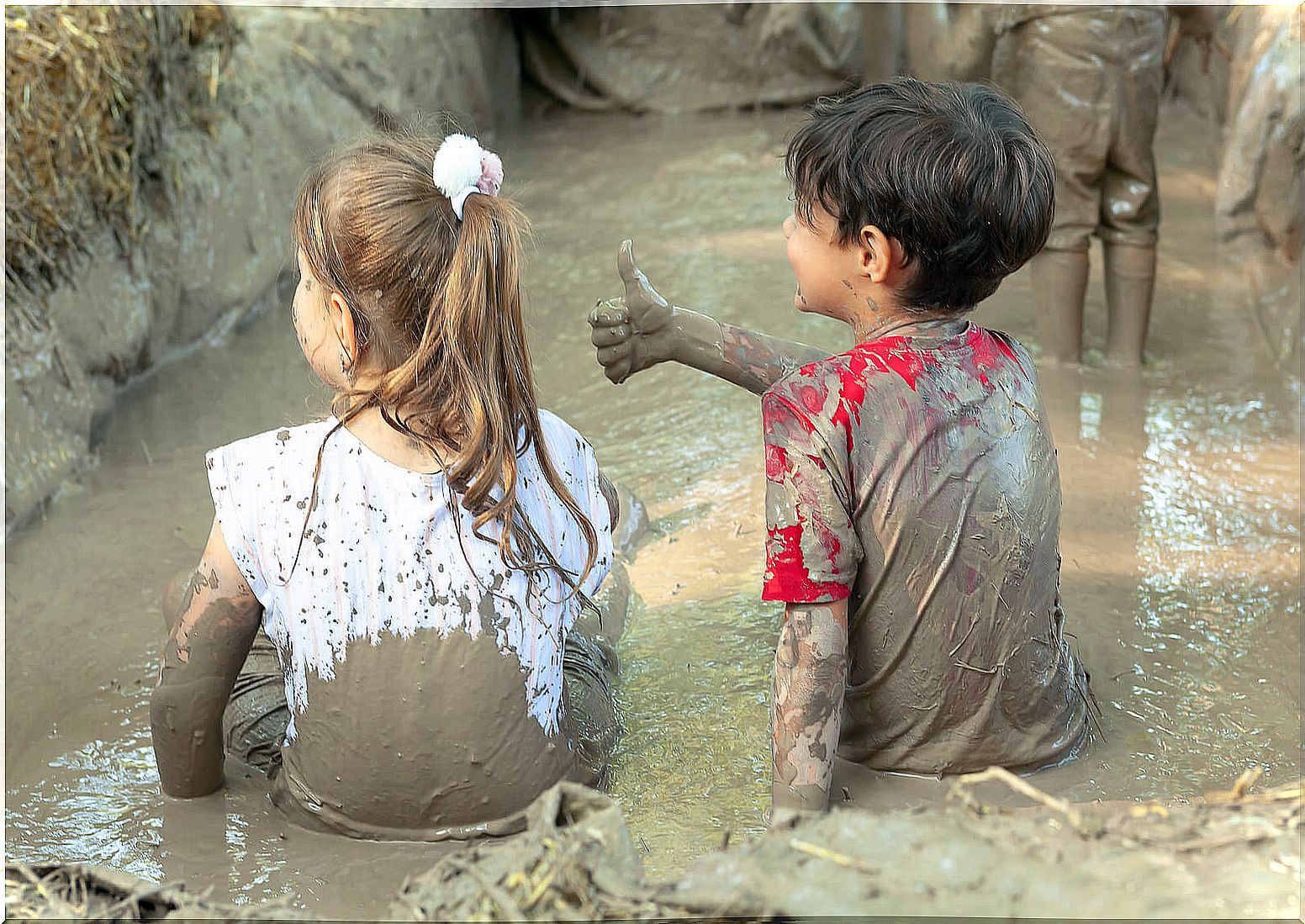 Children in a mud pool learning to let go of control.