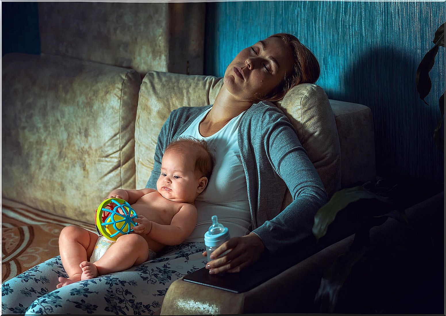 Exhausted mother with her son in her arms because she has not learned to delegate.