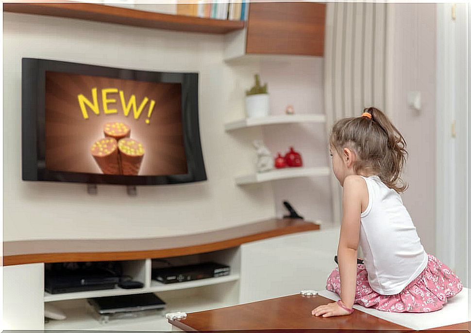 Little girl watching on television commercials.