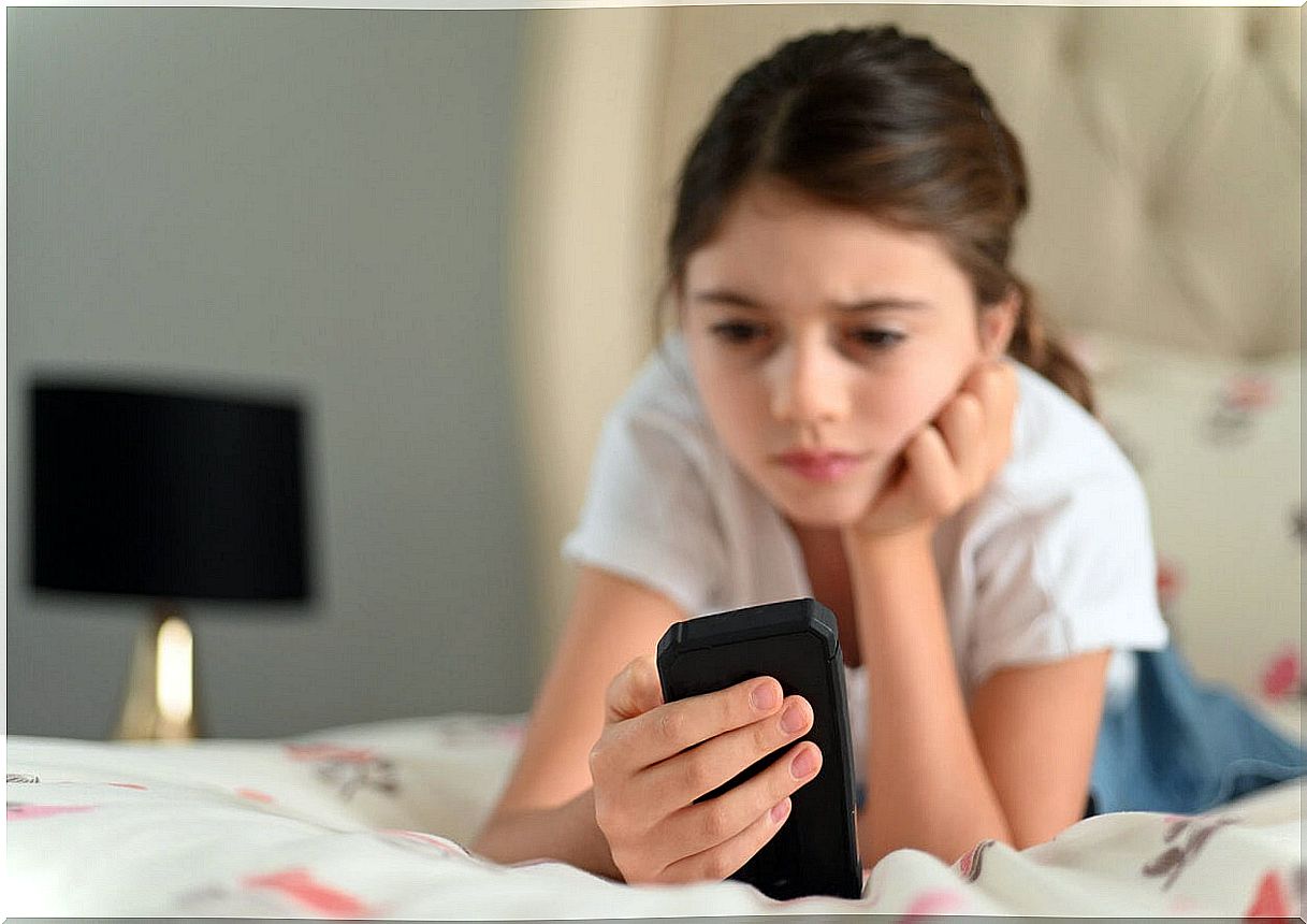 Girl looking at mobile phone suffering from digital stress.