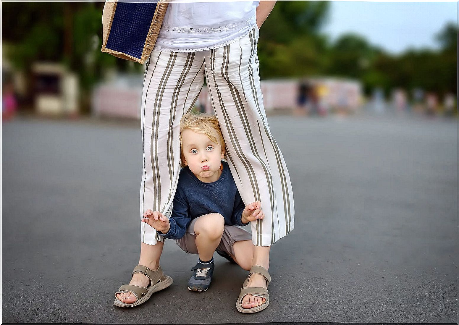 Child playing between the legs of his mother applying obedience according to Montessori.