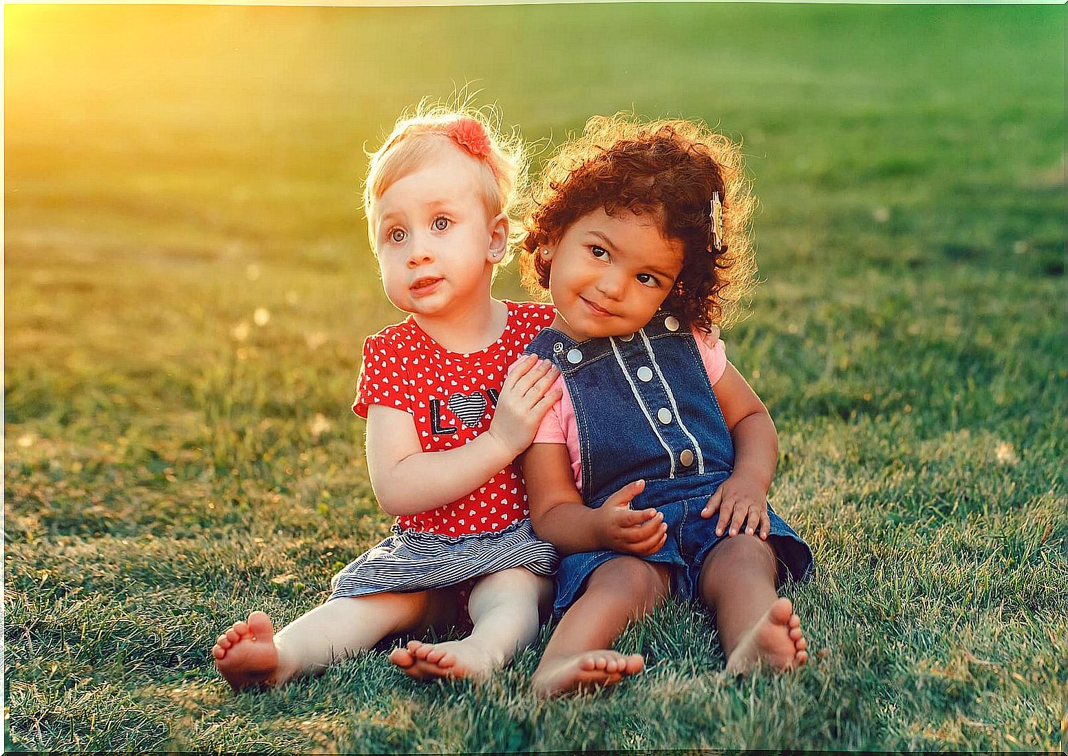 Girl friends sitting on the grass due to personality development in boys.