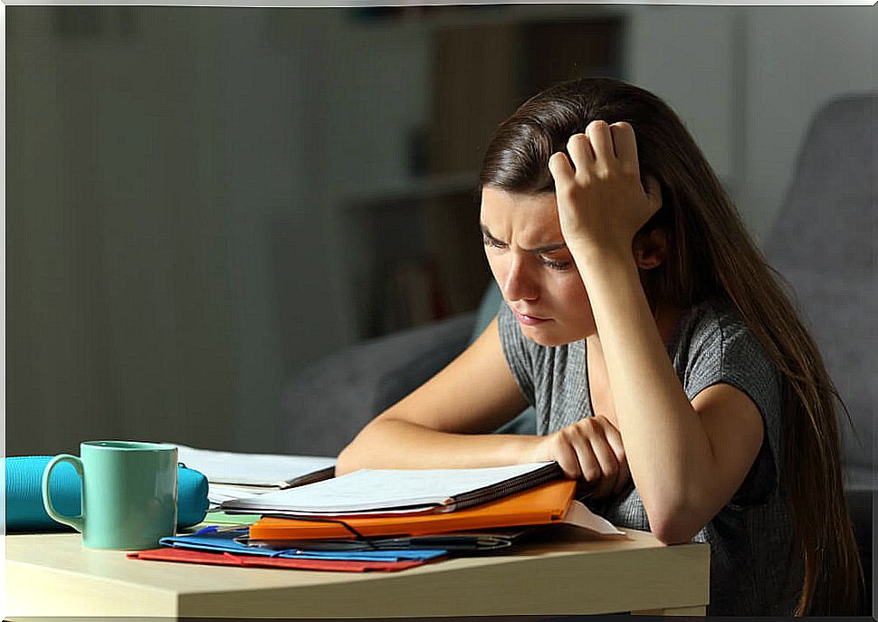 Tired and exhausted teenager in front of his notes to understand and learn effectively.