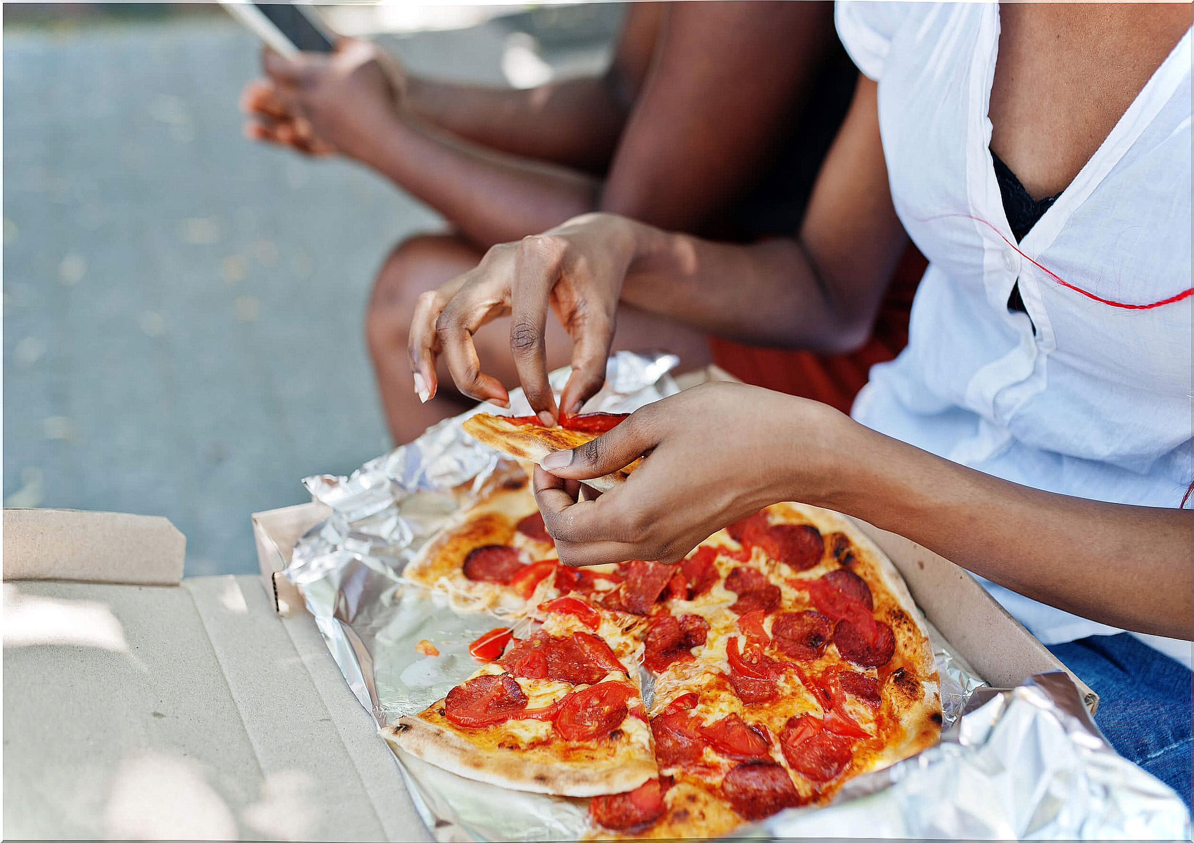 Teen girl eating a pizza.