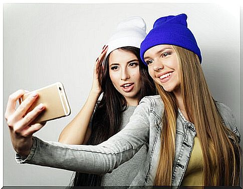 Teens taking a photo to post on Snapchat.