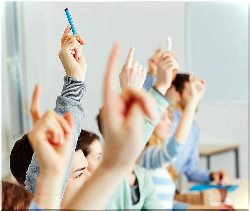 Students raising their hands in class to learn thanks to the metaphor of the reed and the fish.