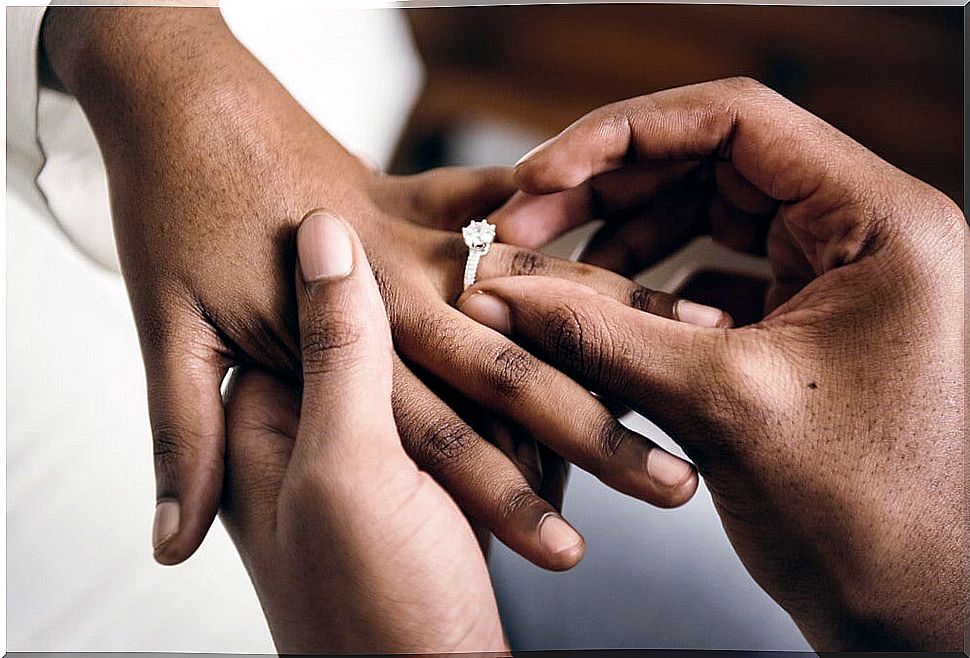 Couple putting on the ring at the wedding and deciding between the different types of marriage regimes.