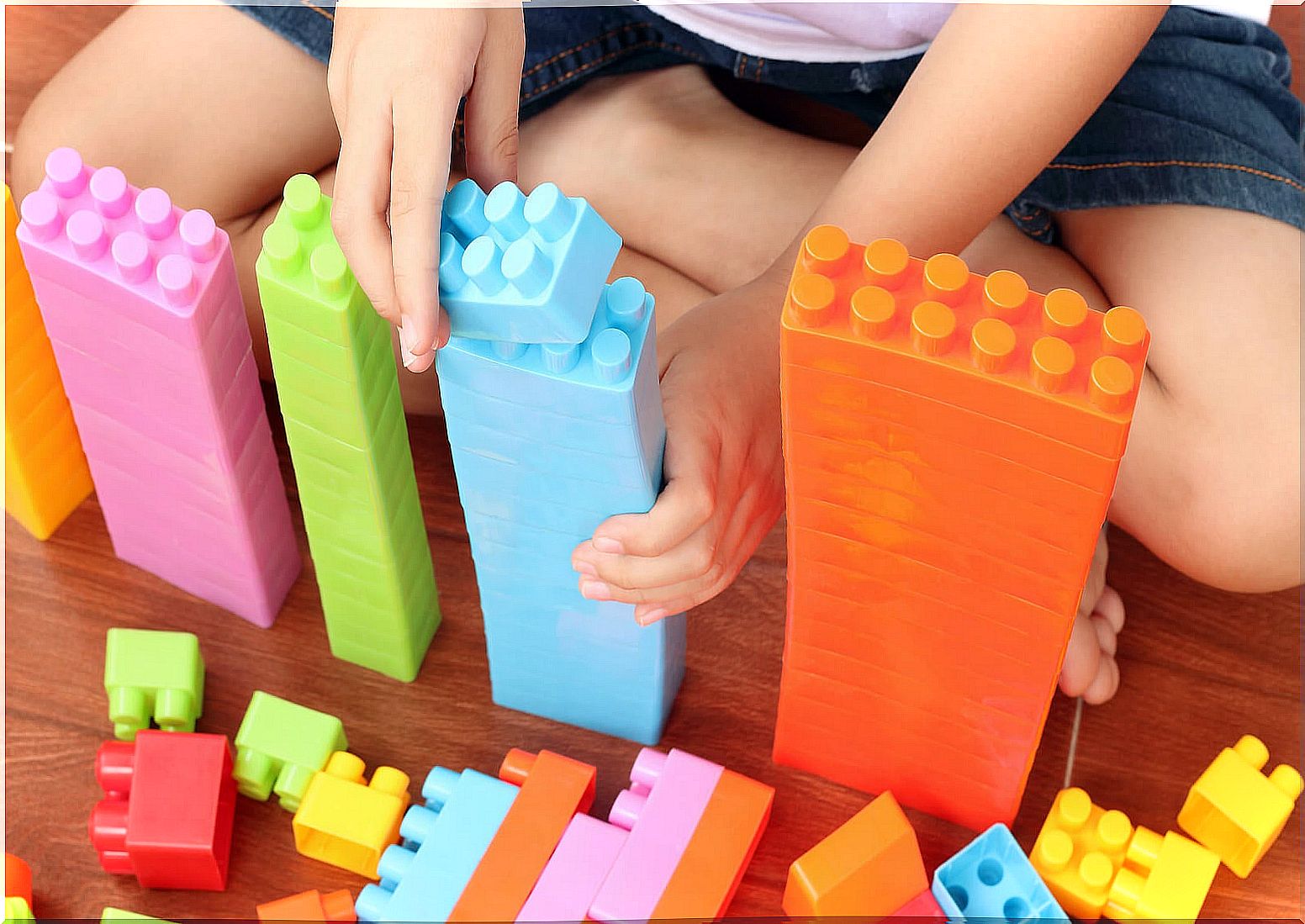 Child making towers when playing with blocks.